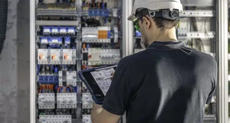 Elektriker mit Tablet vor Schutztechnik | TRIPS