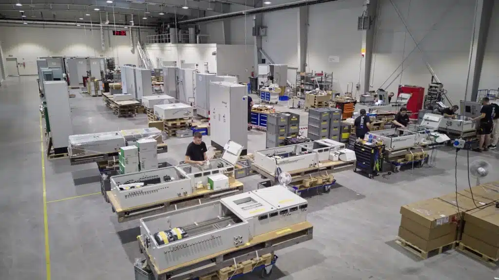 Mitarbeitende beim Schaltschrankbau in Produktionshalle | TRIPS group